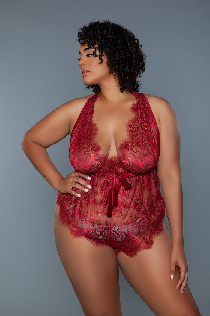 Woman wearing a red lace lingerie set against a gray background