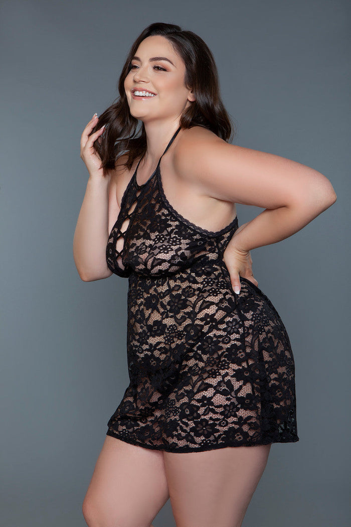 Woman wearing a black lace dress against a gray background