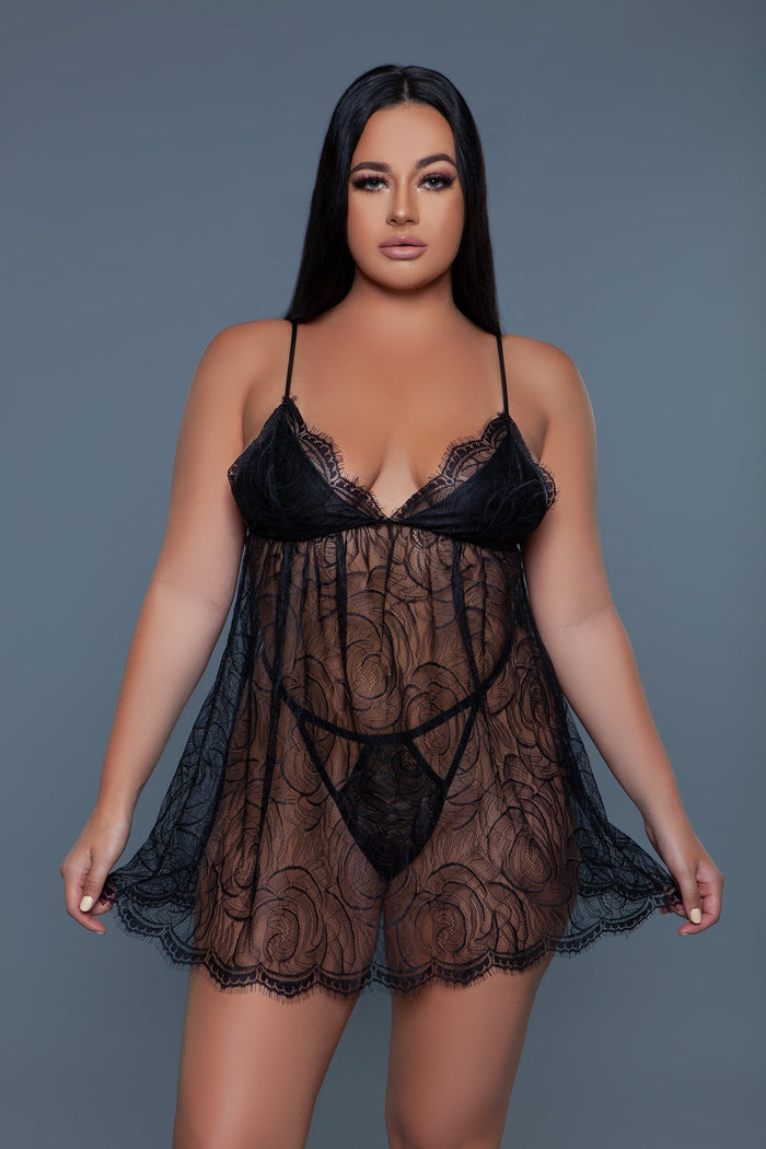 Woman wearing a black lace lingerie set against a gray background