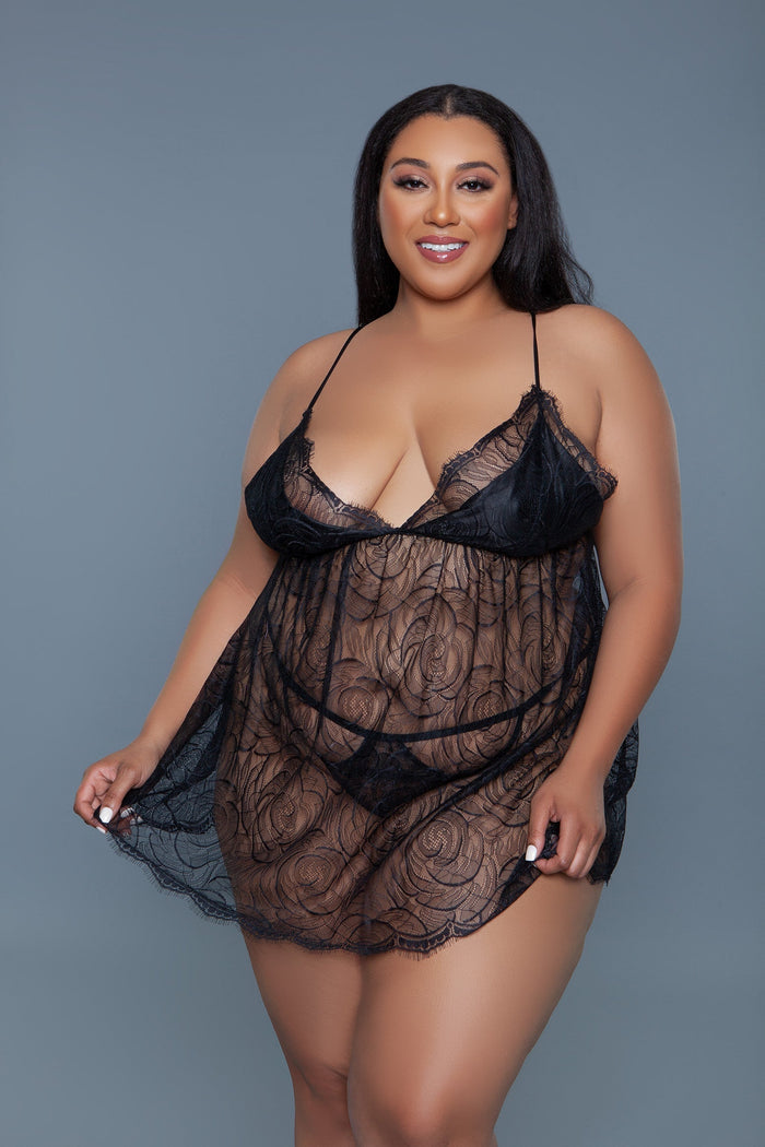 Woman wearing a black lace lingerie set against a gray background