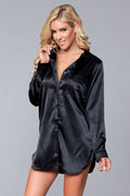Woman wearing a black satin nightshirt against a gray background