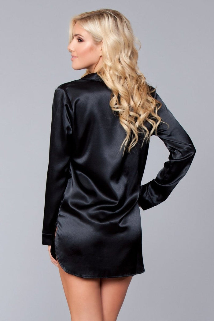 Woman wearing a black satin nightshirt against a gray background