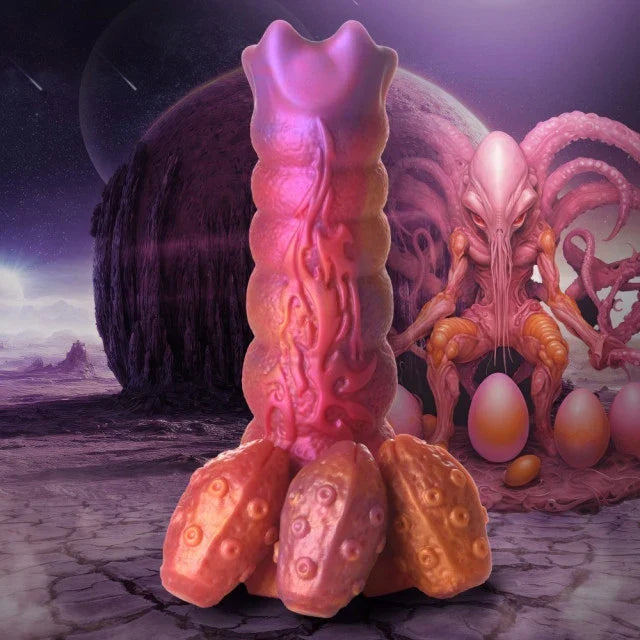 Alien-like creature with a pink and orange body in a desert landscape with eggs.