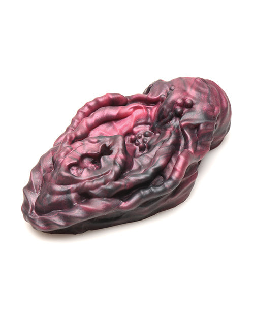 Purple and black stone sculpture on a white background