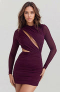 Woman wearing a burgundy dress with long sleeves and cut-out design on a white background