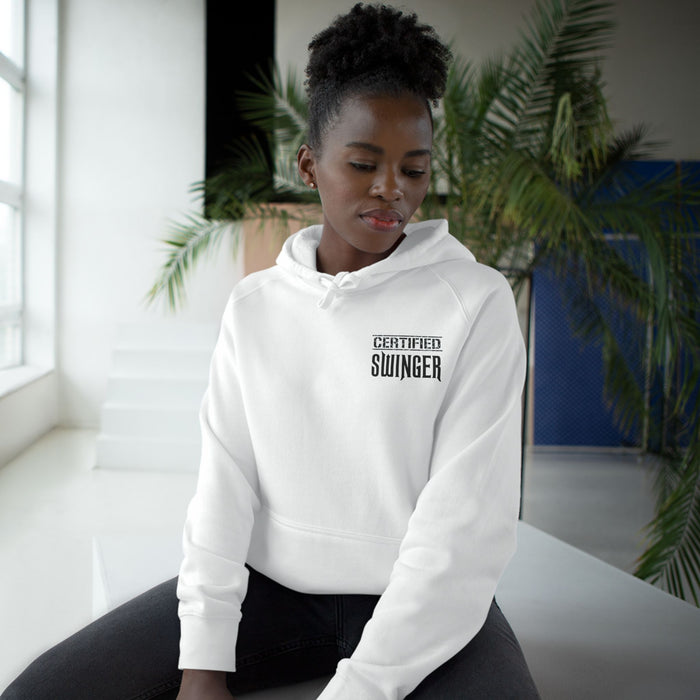 A woman sitting and wearing a white hoodie with 'CERTIFIED SWINGER' text on the front.